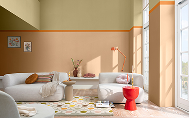 Living room with split wall in soft orange and straw yellow and cream sofa