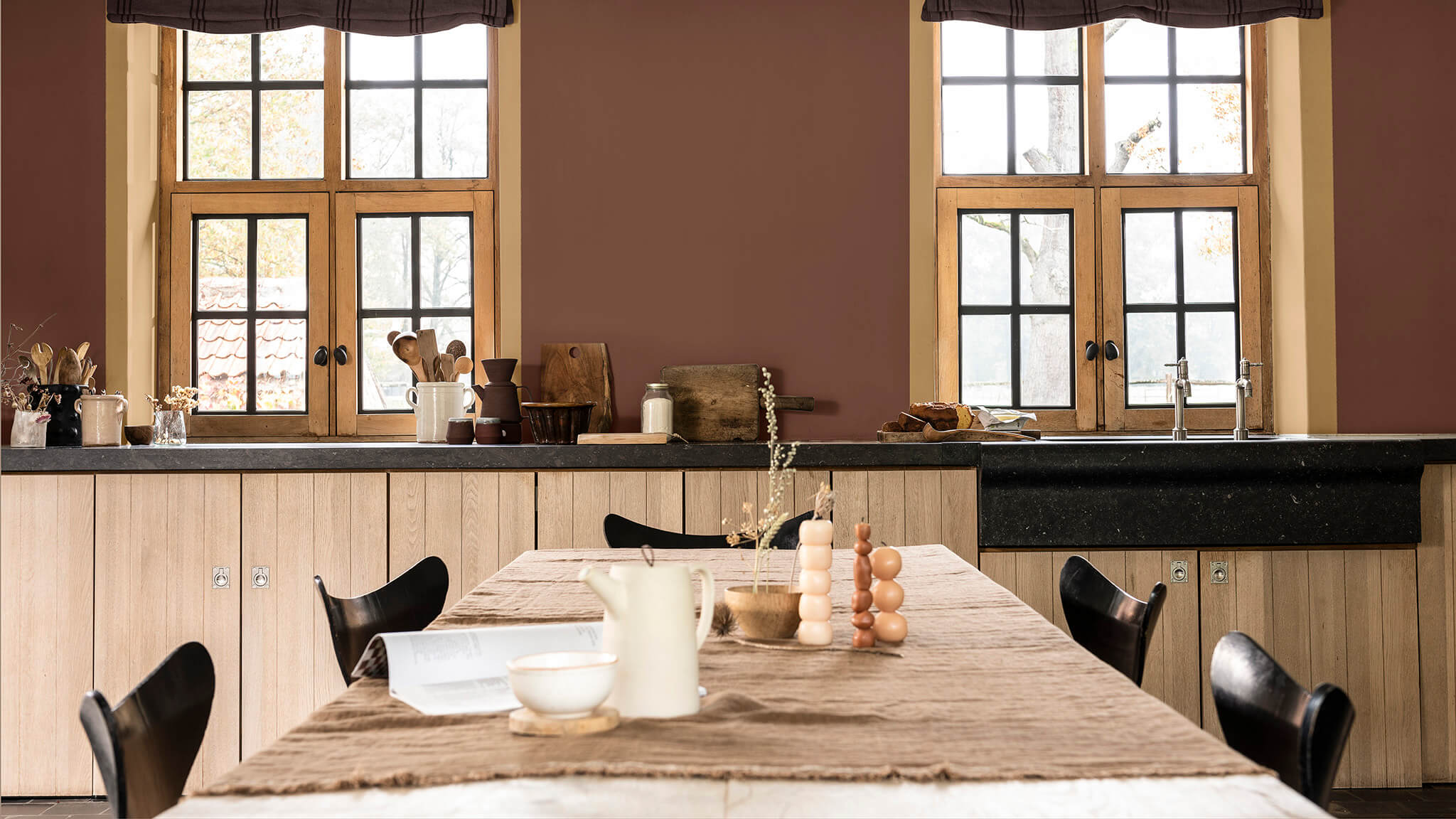 A two tone wall with a round table and white lampshade.