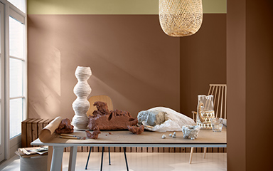 split wall in brown and straw yellow wall with a reqtangular table and rotan lampshade