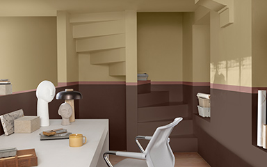 A study with a staircase painted in a split wall using brown and straw yellow 