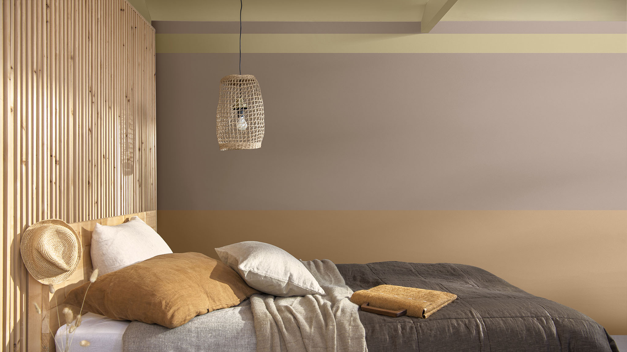 Split wall in a bedroom, combining a rusty orange, pink and straw yellow